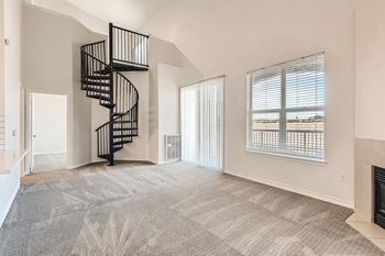 Window coverings and spiral staircase in living room at Fox Run Lofts Apartments, Englewood CO